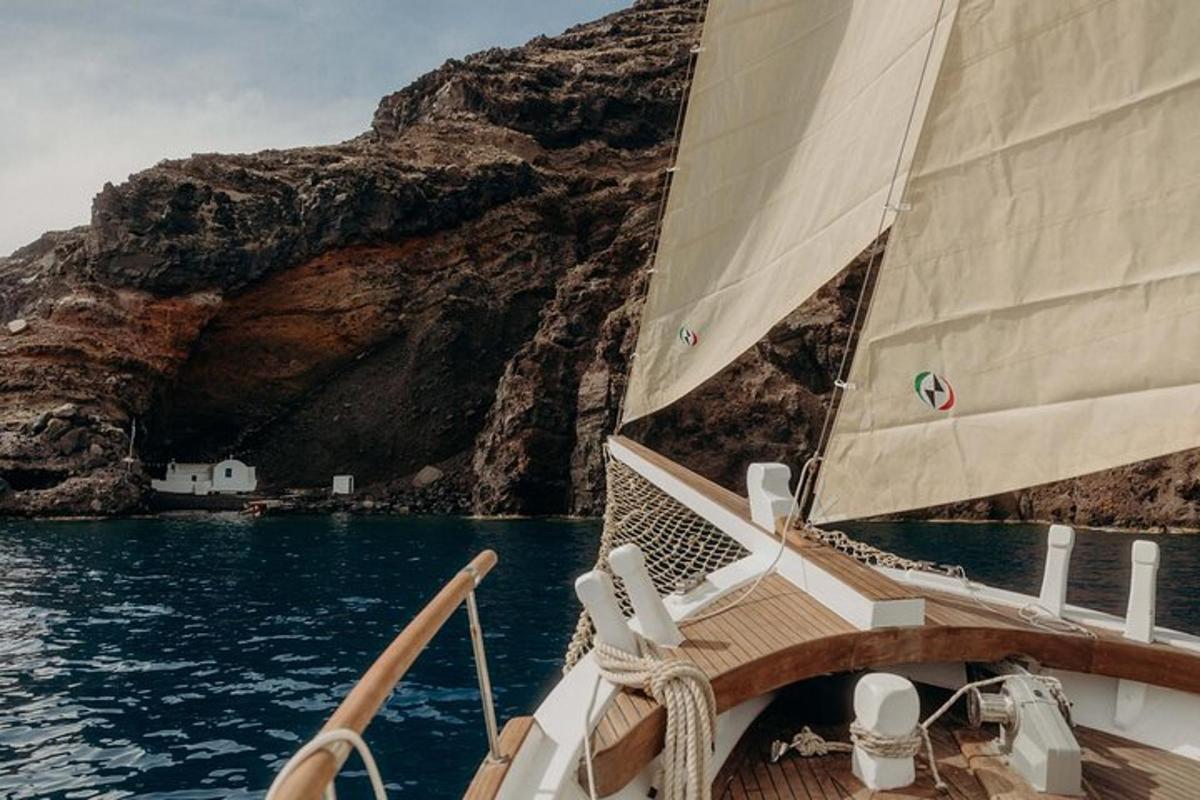 una barca in acqua vicino a una scogliera