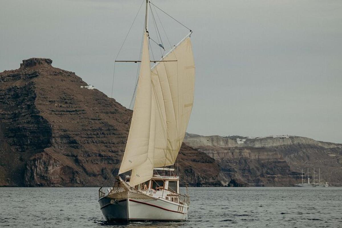 una barca a vela in acqua con una montagna sullo sfondo
