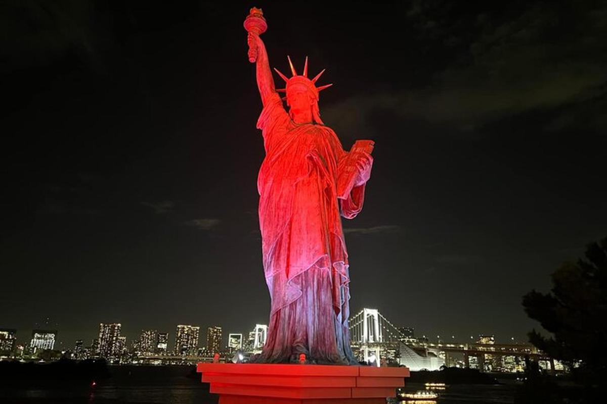 uma estátua iluminada da estátua da liberdade à noite