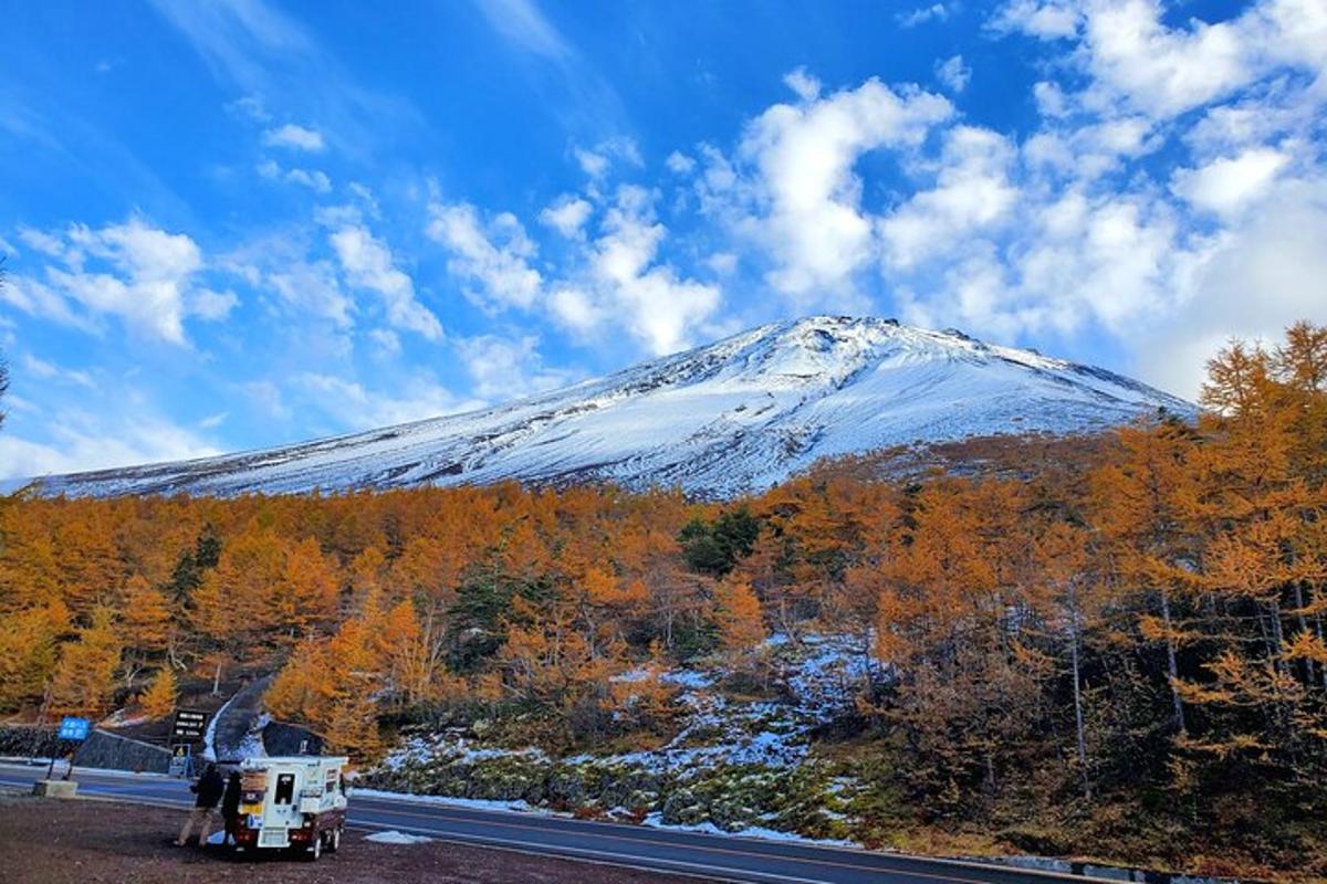 gunung yang dilitupi salji dengan trak di jalan raya