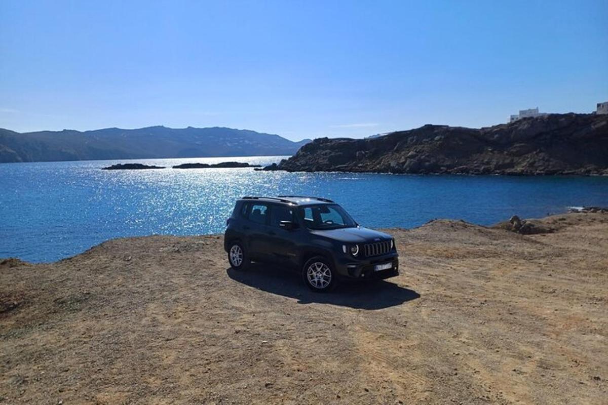 una jeep nera parcheggiata accanto a uno specchio d'acqua