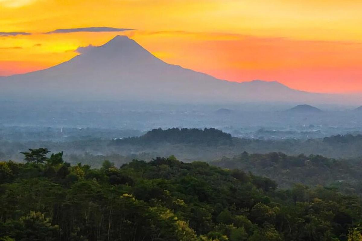a view of a mountain with a sunset in the background