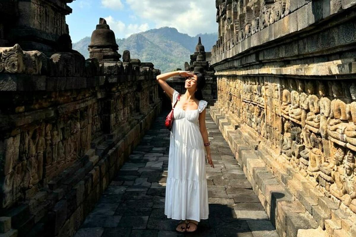 a woman in a white dress standing on a wall