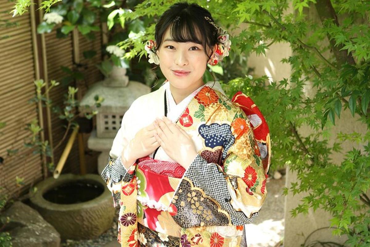 seorang wanita memakai kimono berdiri di taman