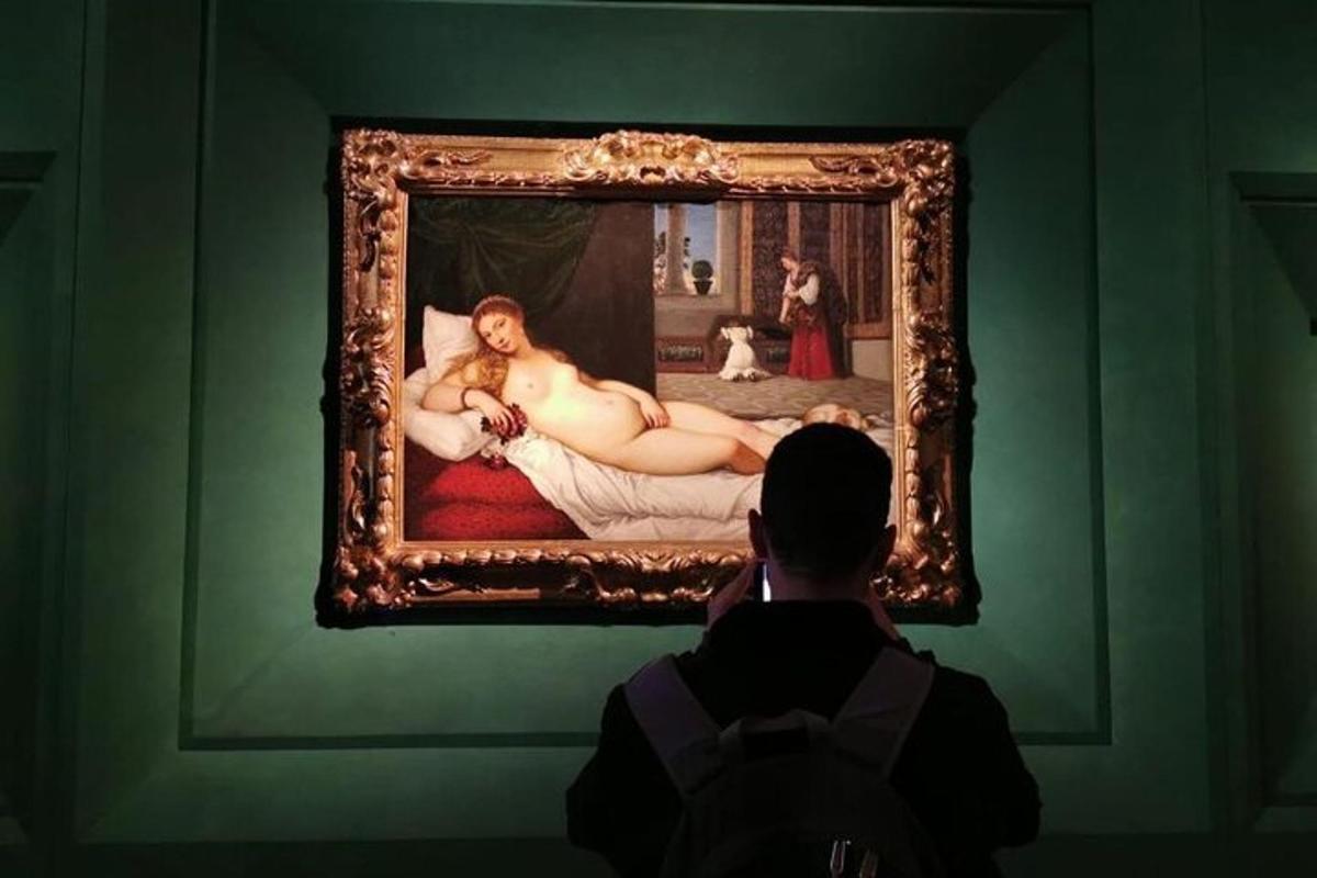 muž fotografující obraz v muzeu