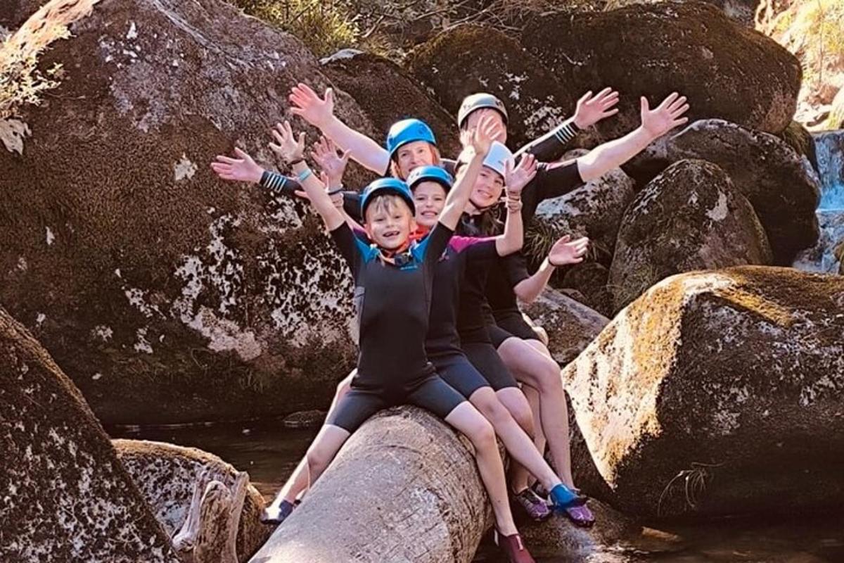 a group of children sitting on rocks in the water