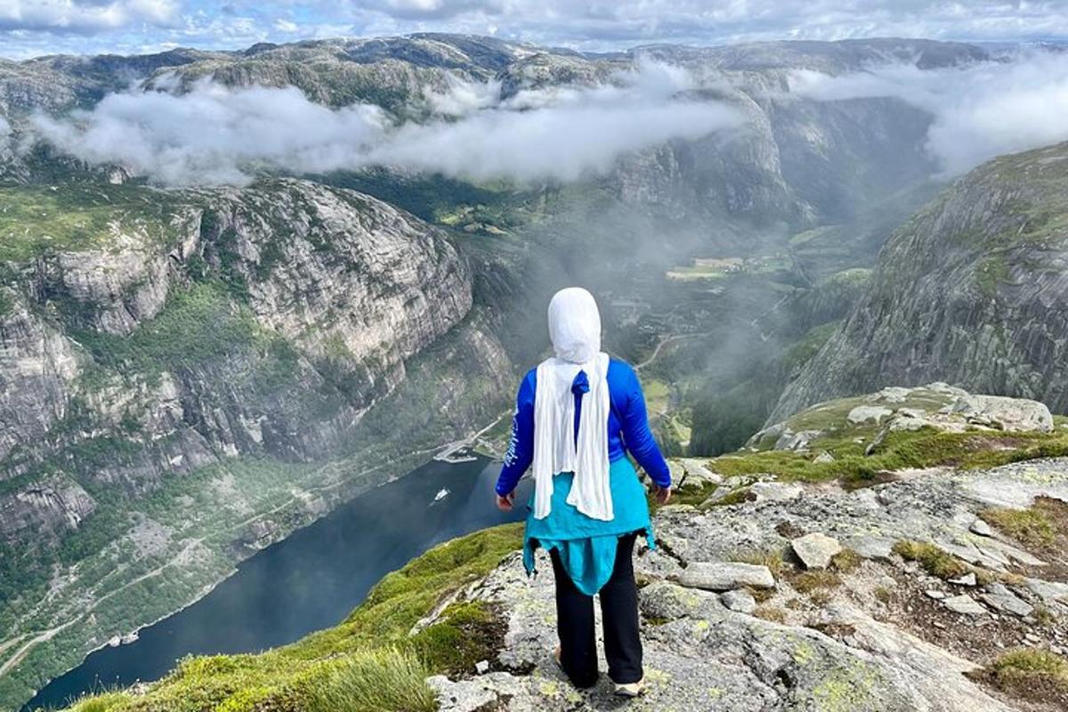 maður stendur á fjallstindi og horfir yfir dal