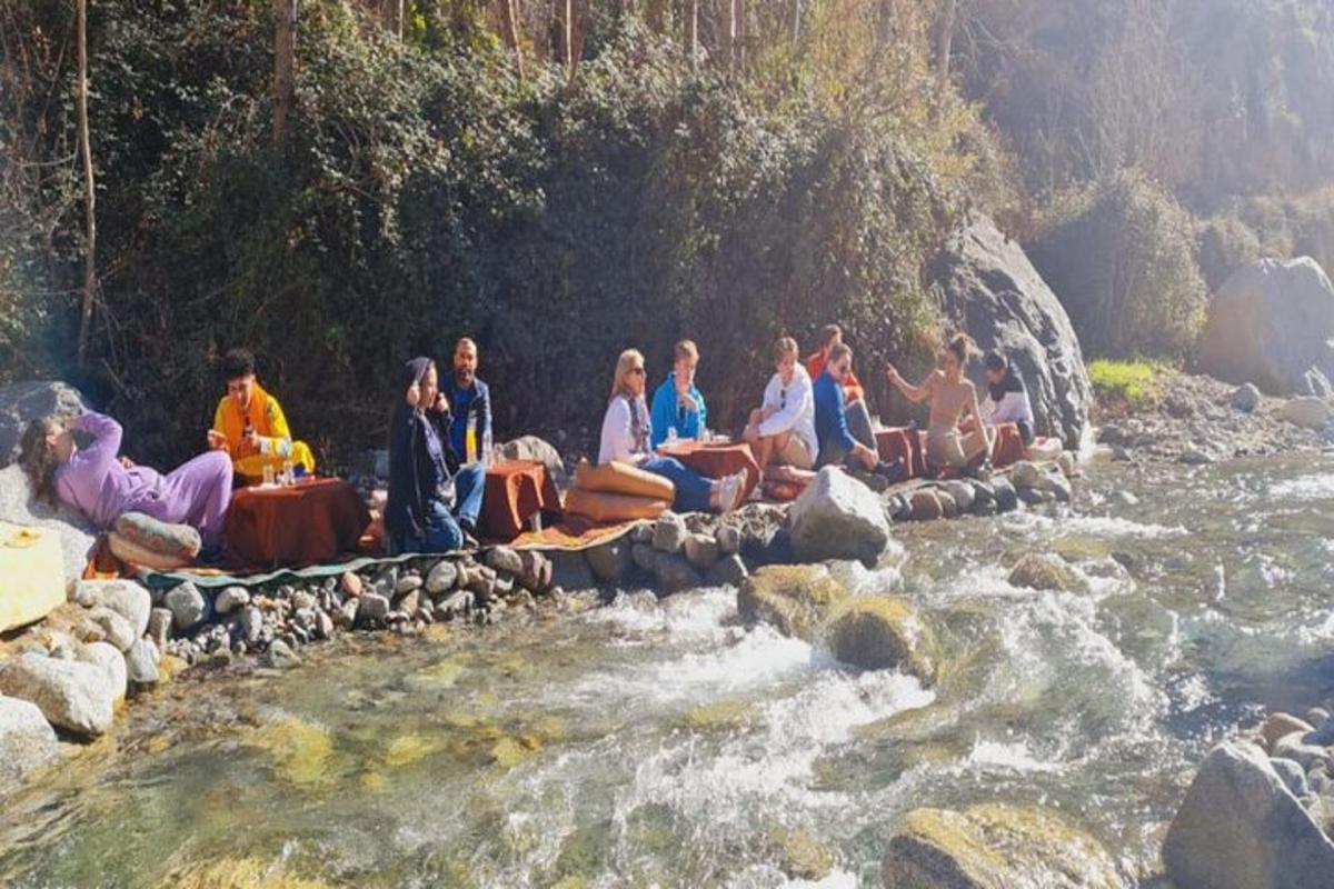 a group of people sitting on rocks in a river