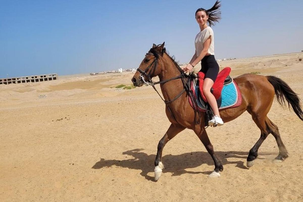 žena jedoucí na koni na pláži