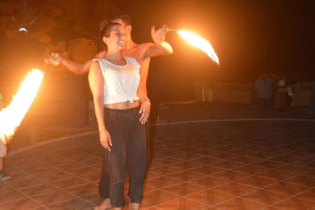 seorang pria berdiri di lantai dansa dengan api