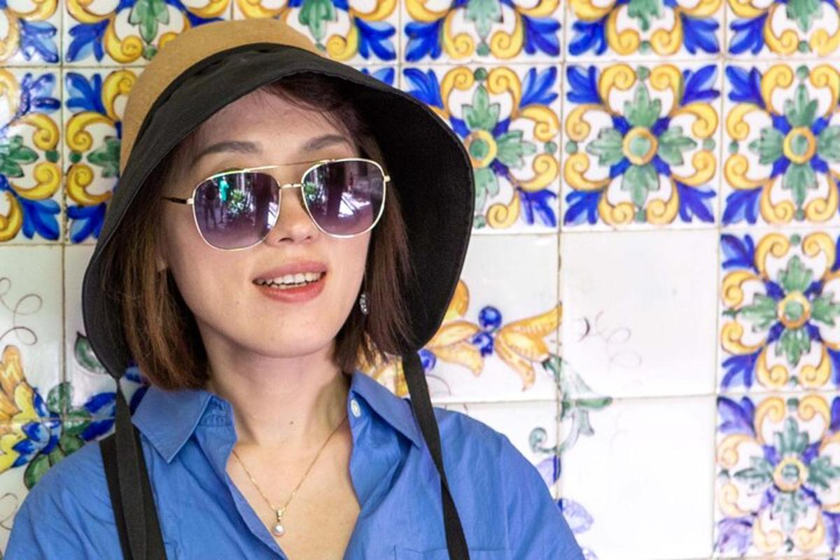una donna che indossa occhiali da sole, un cappello e degli occhiali