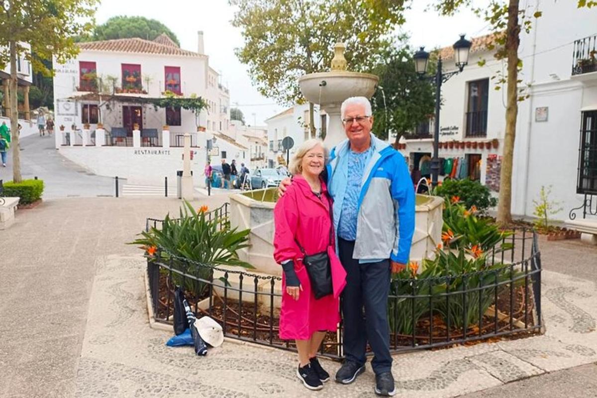 een oudere man en vrouw staan voor een fontein