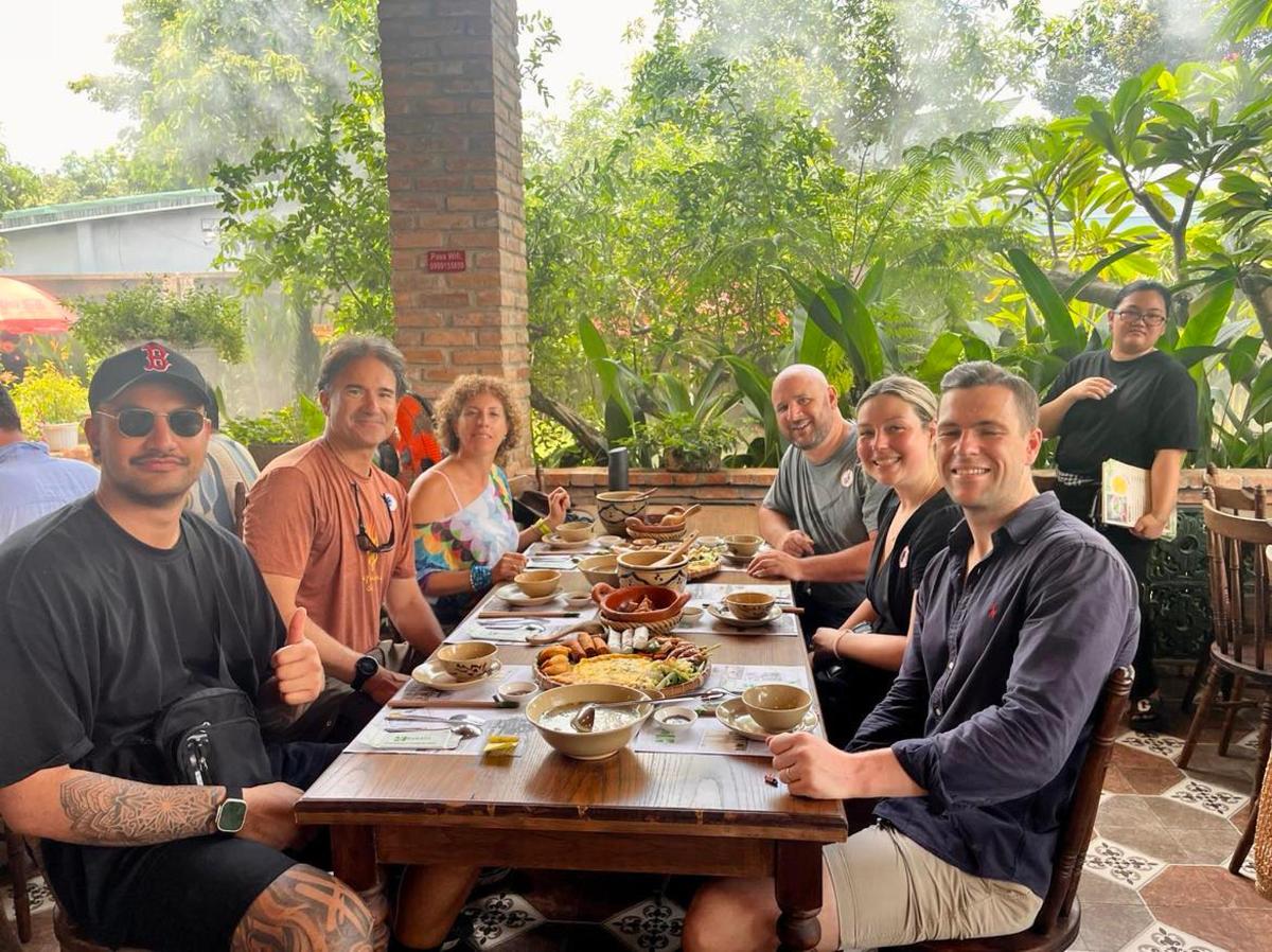 a group of people sitting around a table with food