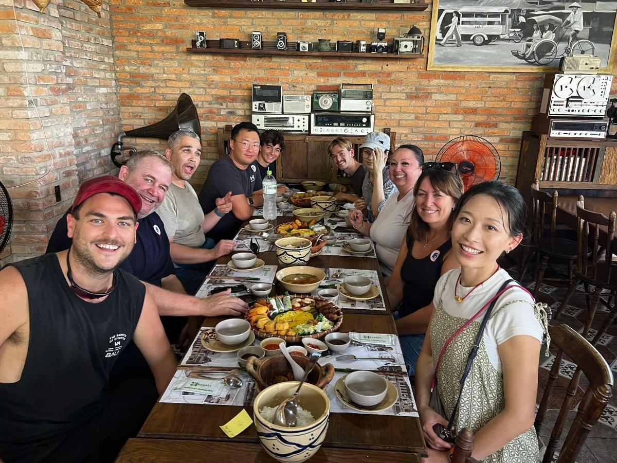 a group of people sitting around a table with food