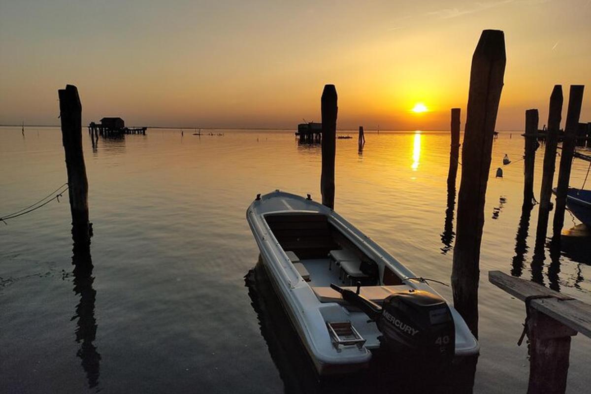 a boat in the water near a dock with the sunset