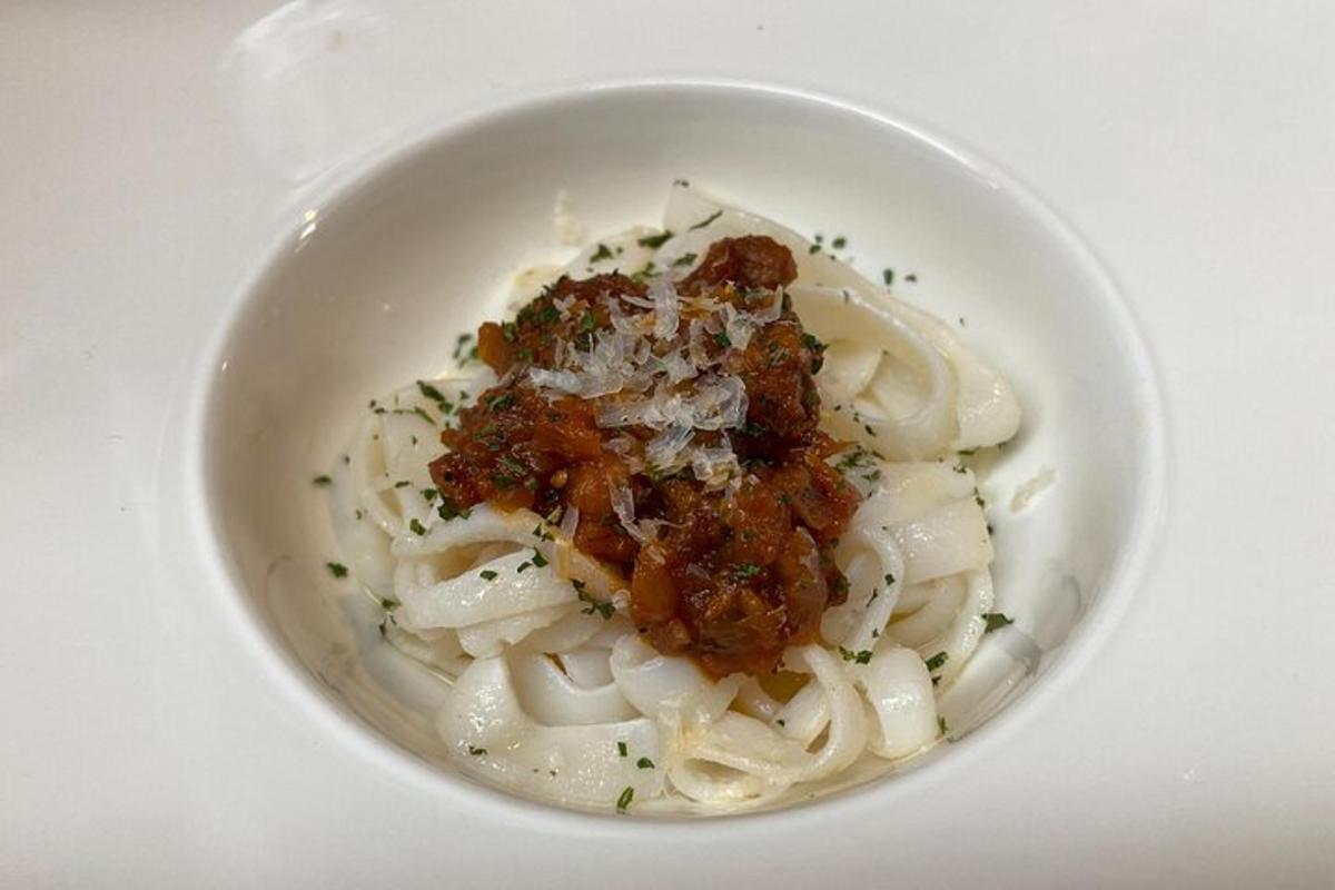 semangkuk putih pasta dengan daging dan sos