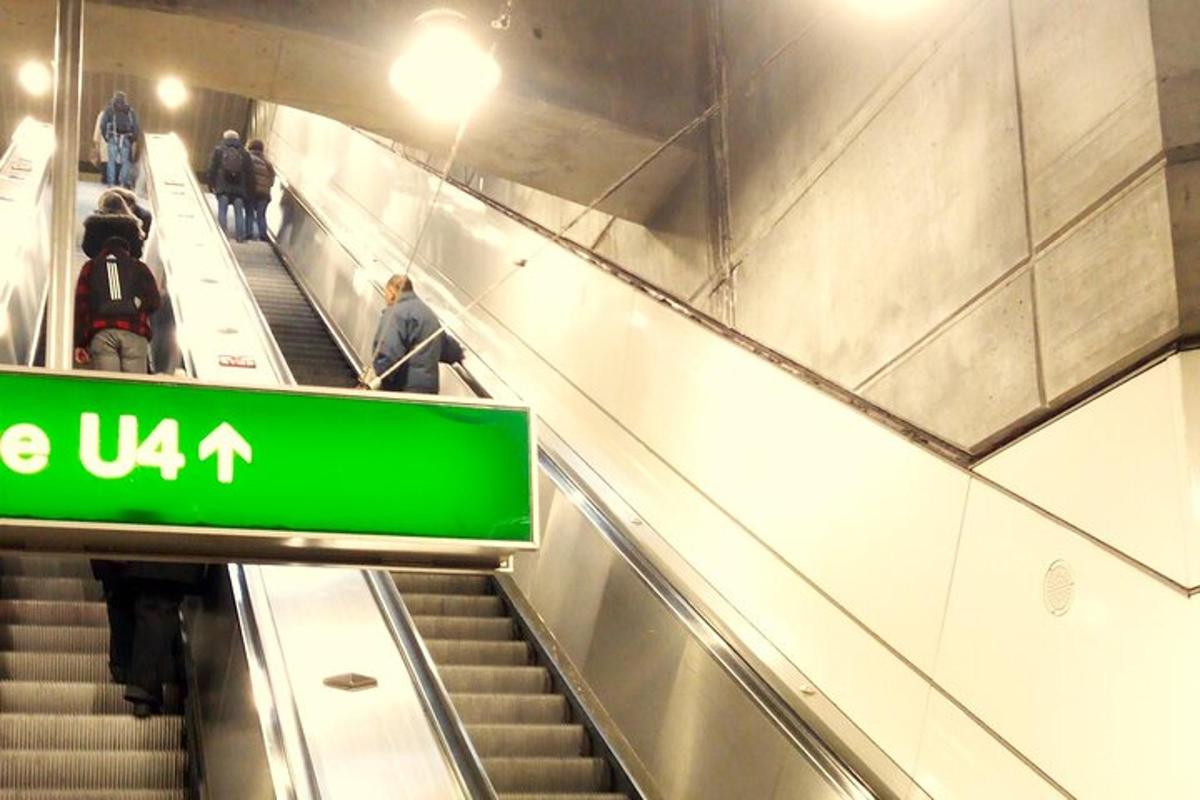 egy mozgólépcső, rajta zöld táblával, rajta emberekkel