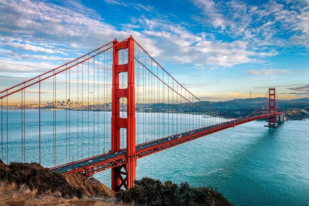 un grande ponte rosso sull'acqua con una città