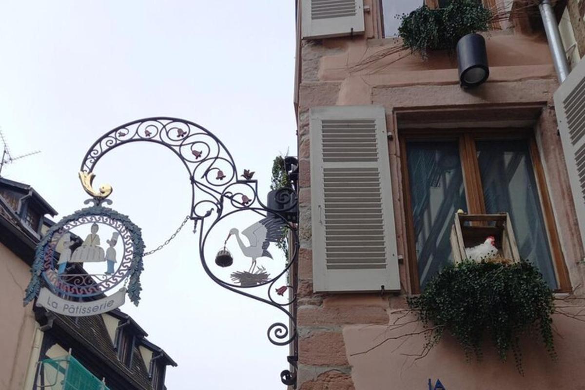 ein Gebäude mit einem Schild und einem Fenster mit einer Katze darin