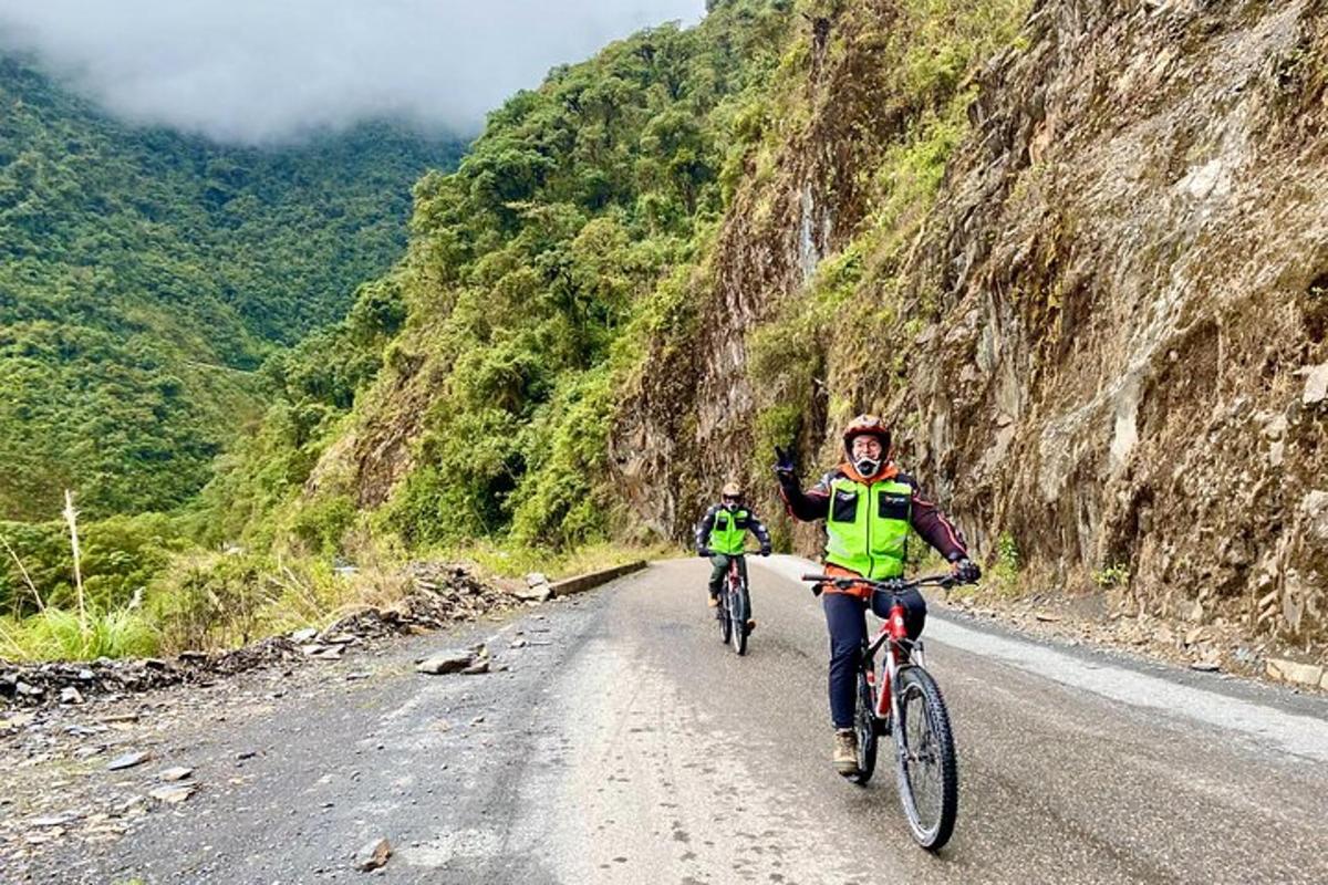 dua orang menunggang basikal menuruni jalan gunung