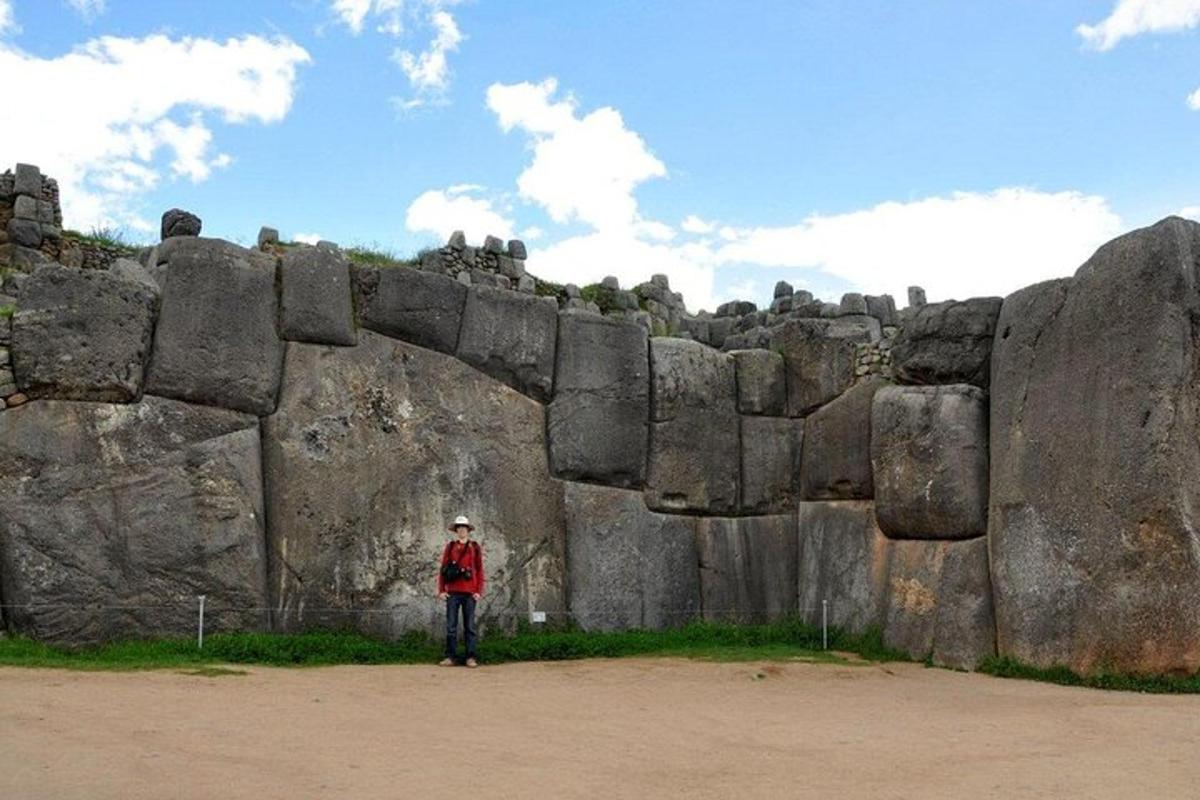 una persona dempeus davant d'una gran paret de roca