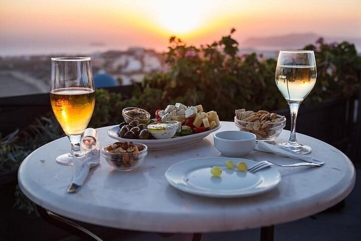 un tavolo con un piatto di cibo e due bicchieri di vino
