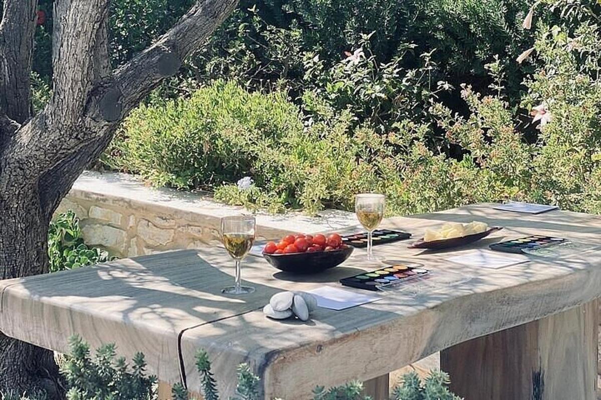 un tavolo con due bicchieri di vino e una ciotola di frutta