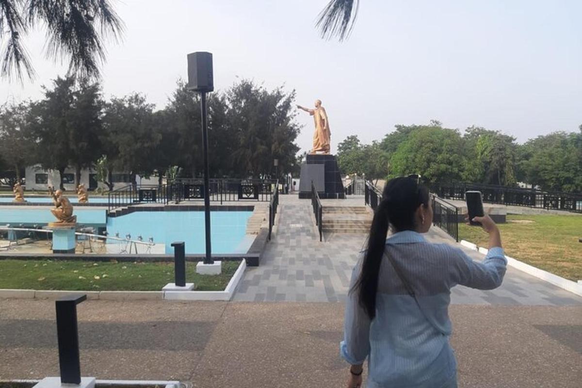 a woman taking a picture of a statue in a park