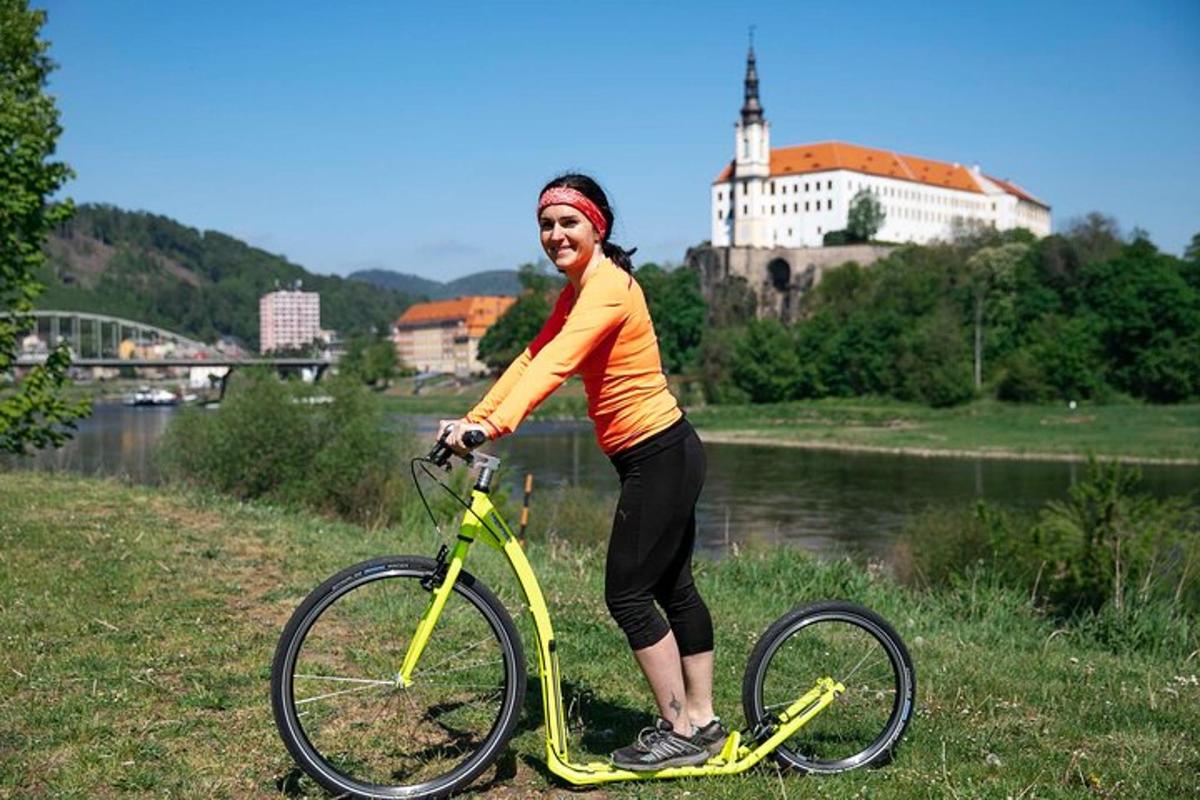 sieviete stāv uz dzeltena velosipēda