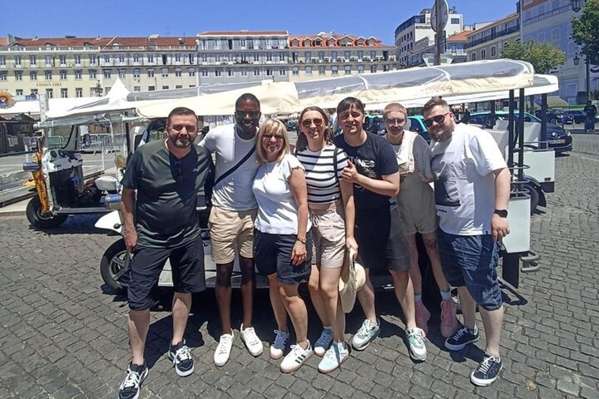 skupina lidí pózujících pro fotografii před vozidlem