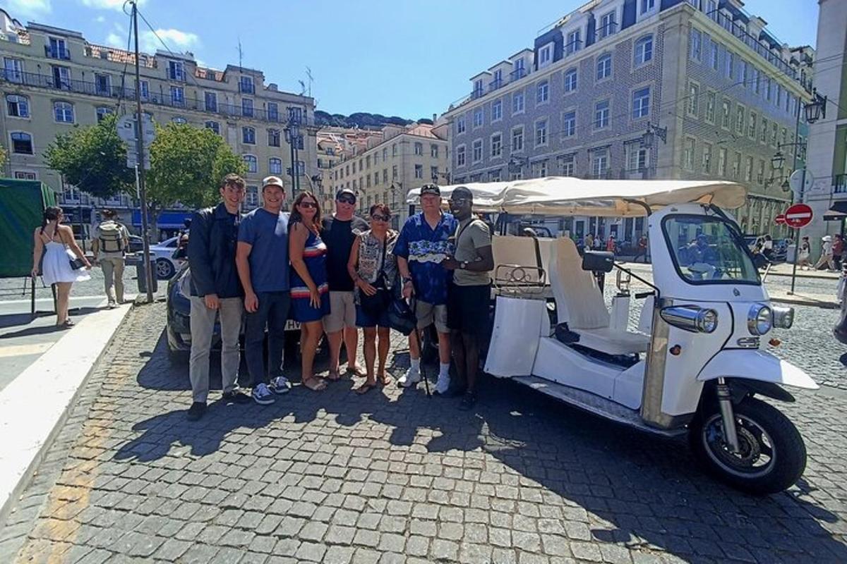 un grup de oameni care stau lângă o căruță de golf