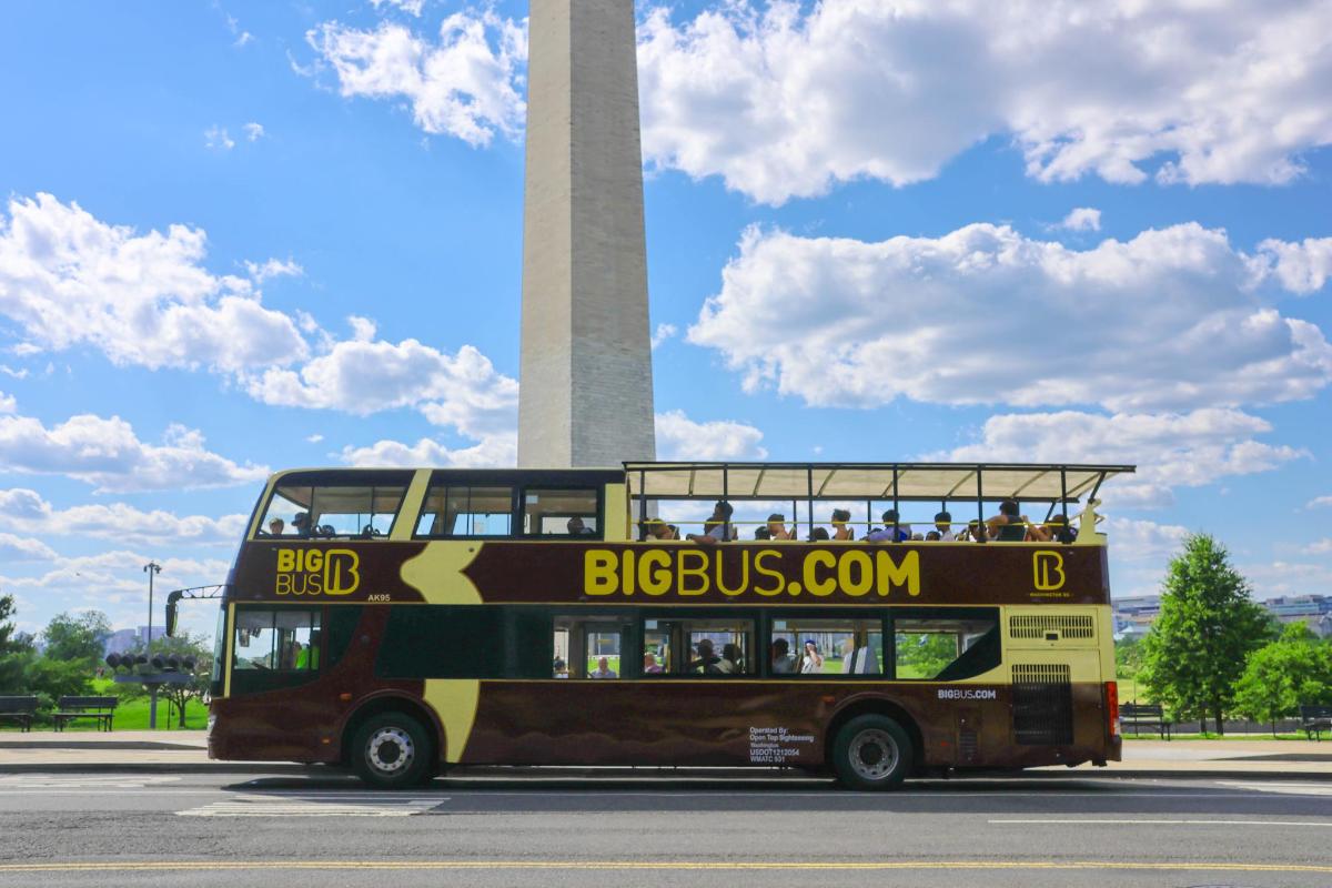 un autobuz cu etaj care trece pe lângă monumentul lui Washington
