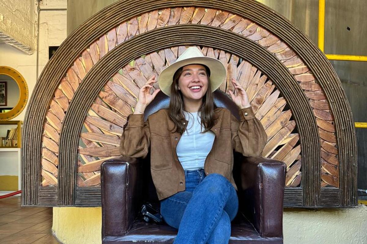 una donna seduta su una sedia che indossa un cappello da cowboy