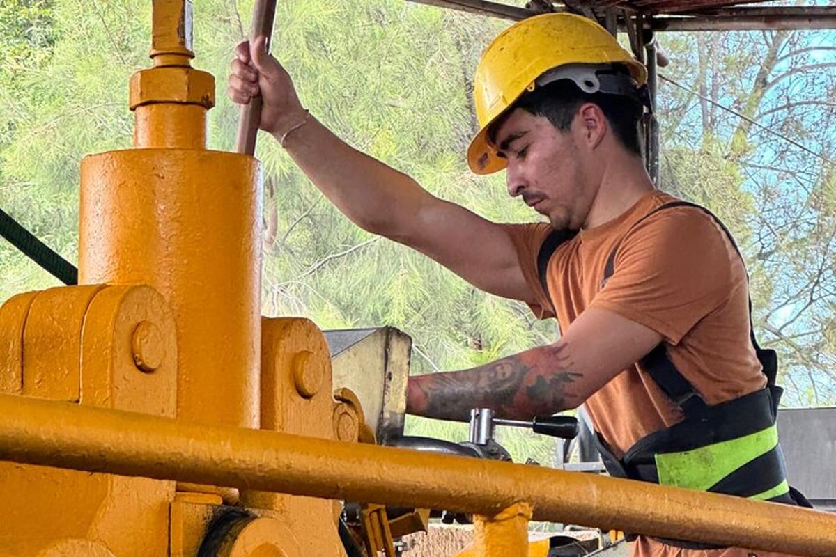 un uomo che indossa un casco che lavora su una macchina gialla