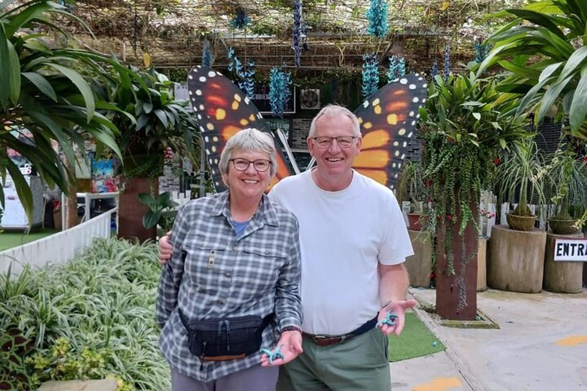 un uomo anziano e una donna in piedi in un giardino