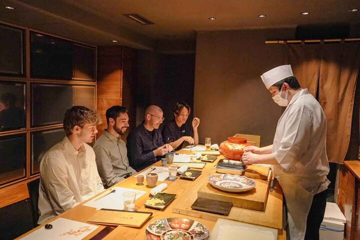 a group of people sitting around a table with a chef