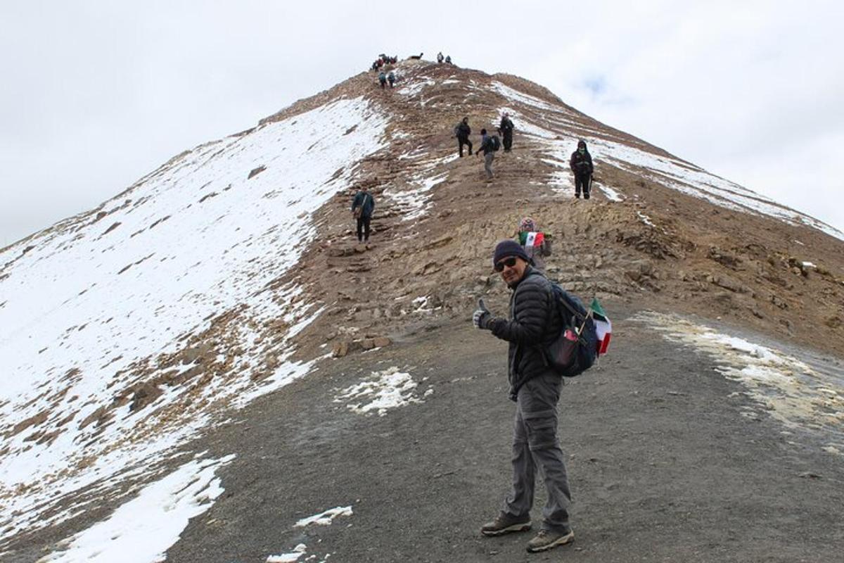 un homme debout au sommet d'une colline couverte de neige