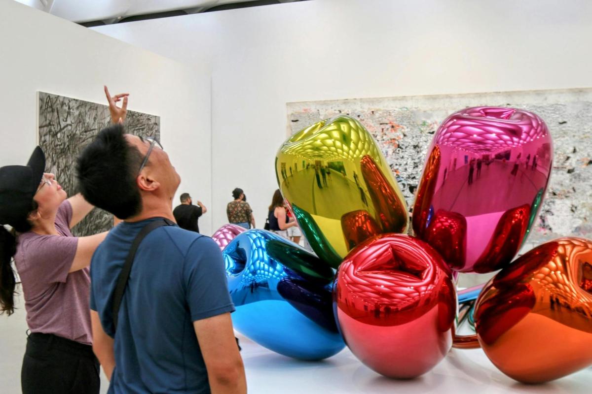 a group of people looking at art in a museum