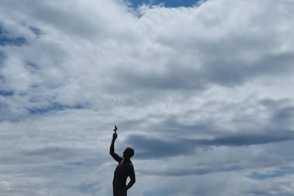 a statue of a person holding a kite in the sky
