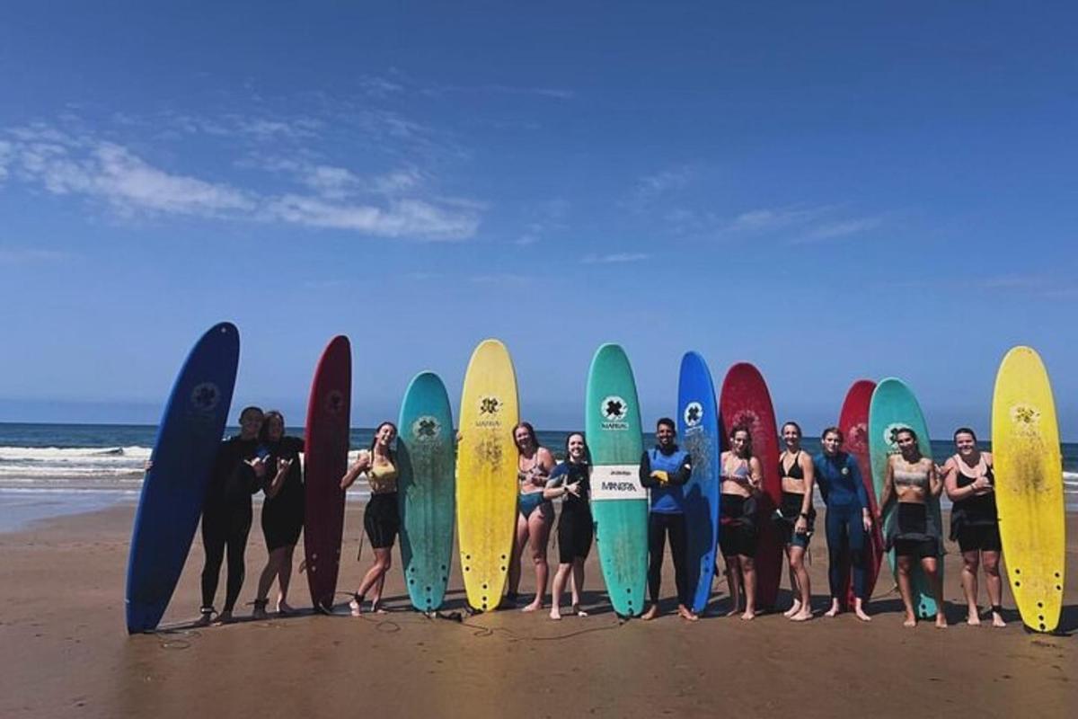 skupina ljudi, ki držijo svoje deske za surfanje na plaži