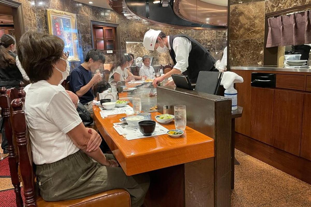kuchař připravující jídlo u stolu v restauraci