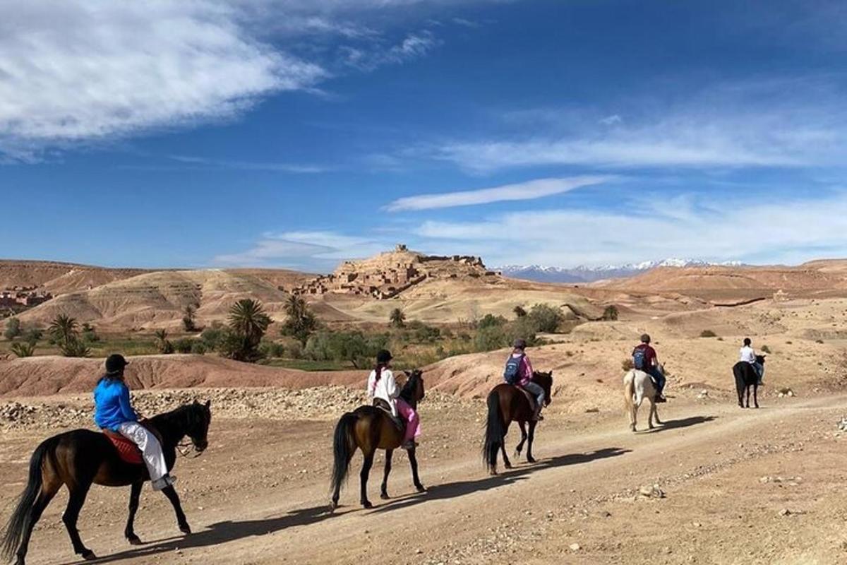 a group of people riding horses in the desert