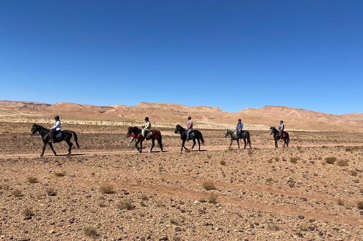 a group of people riding horses in the desert