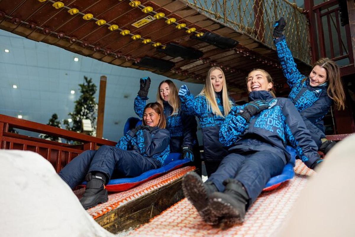 a group of people laying on a slide in the snow