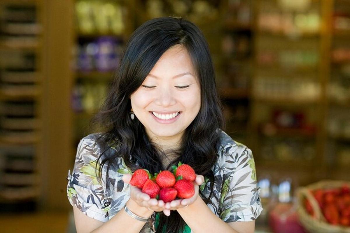 a woman is holding a bunch of strawberries