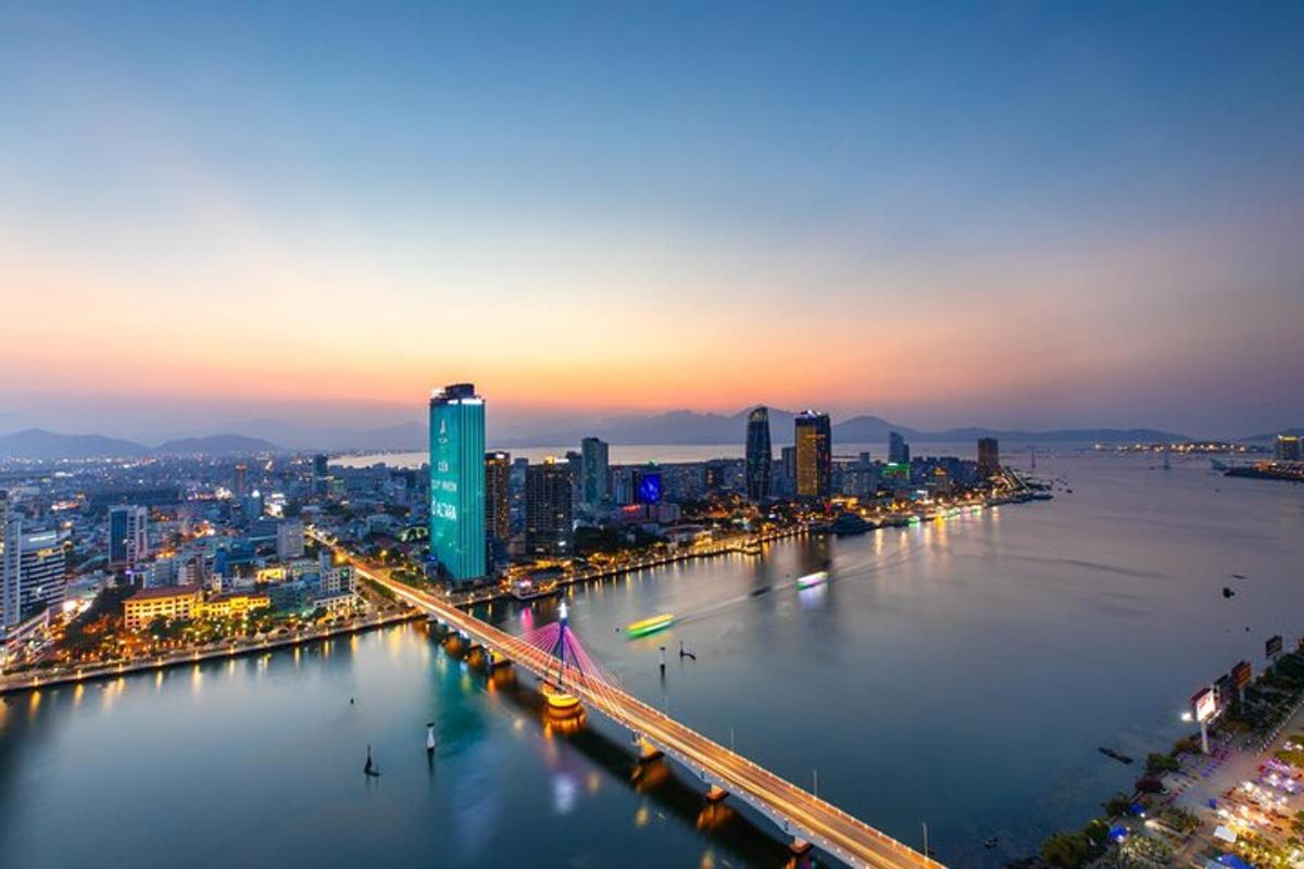 uma cidade com uma ponte sobre um rio à noite