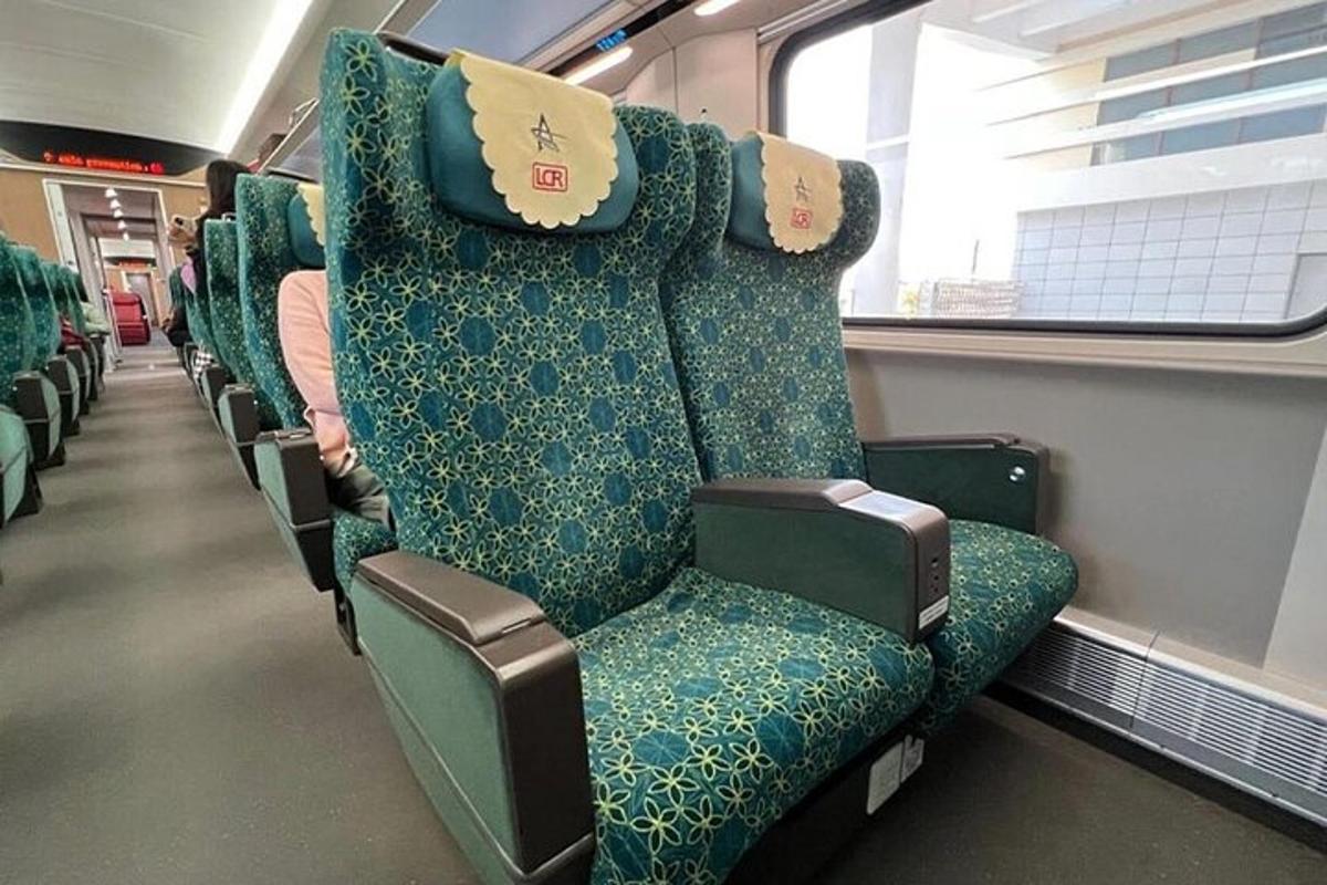 un vagon de tren gol cu scaune verzi și o fereastră