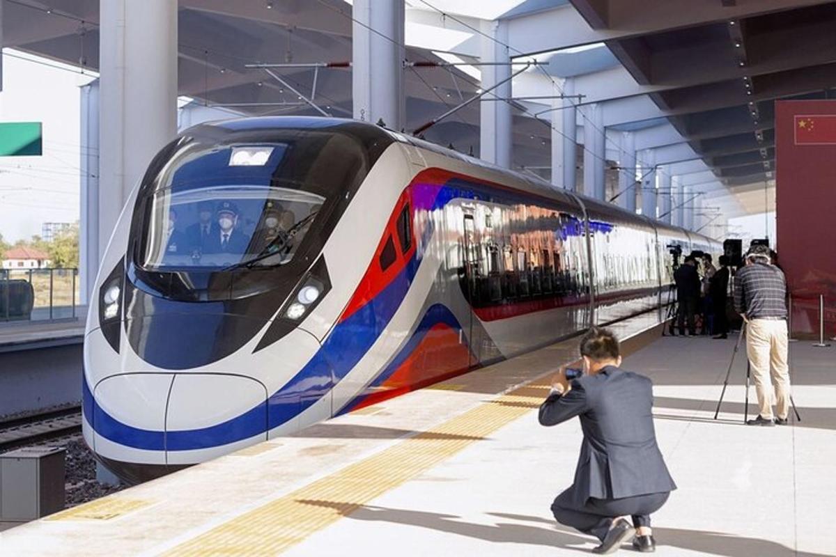 o persoană care fotografiază un tren într-o gară