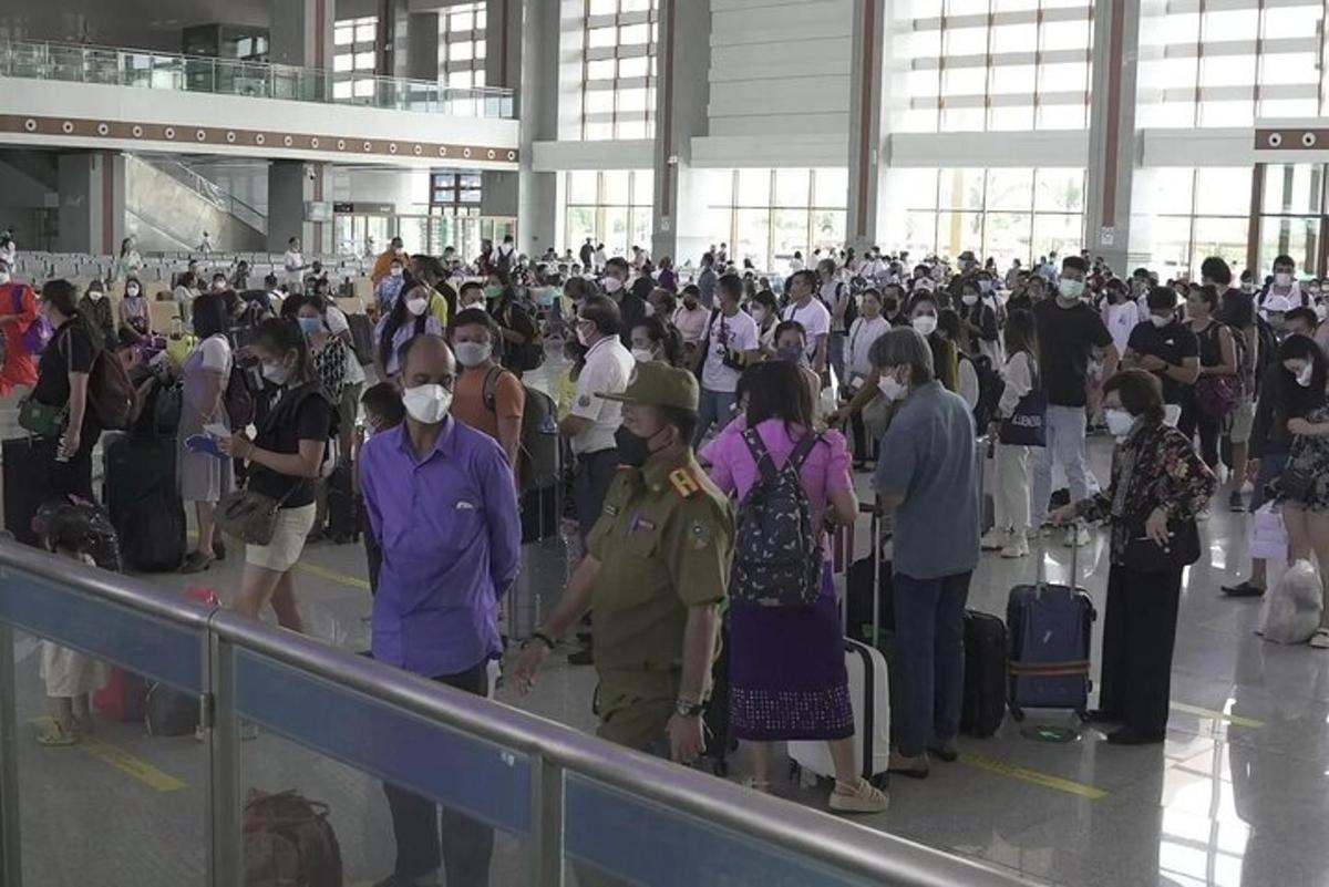 een groep mensen die op een luchthaven op hun bagage wacht