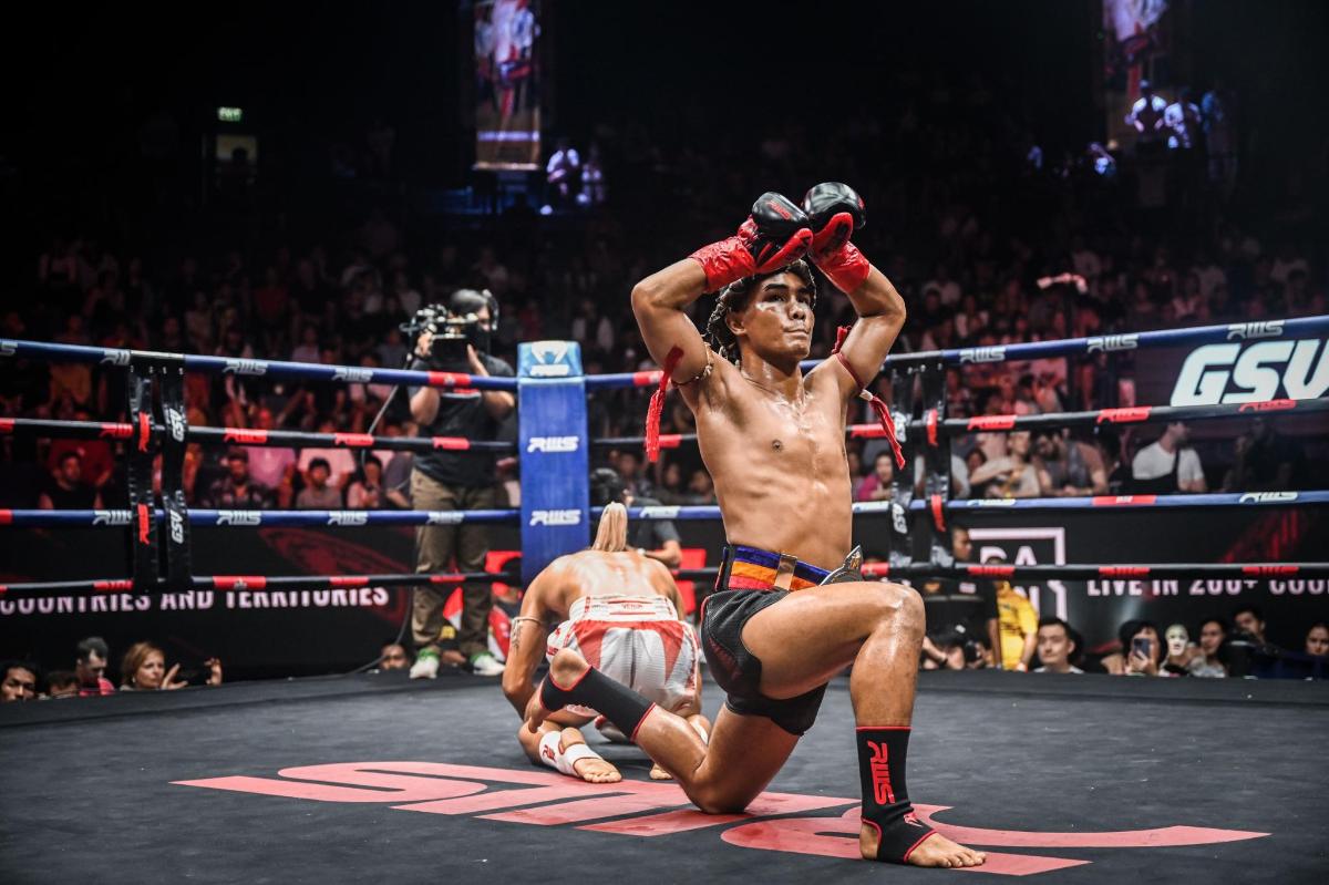 a shirtless man is sitting in a boxing match